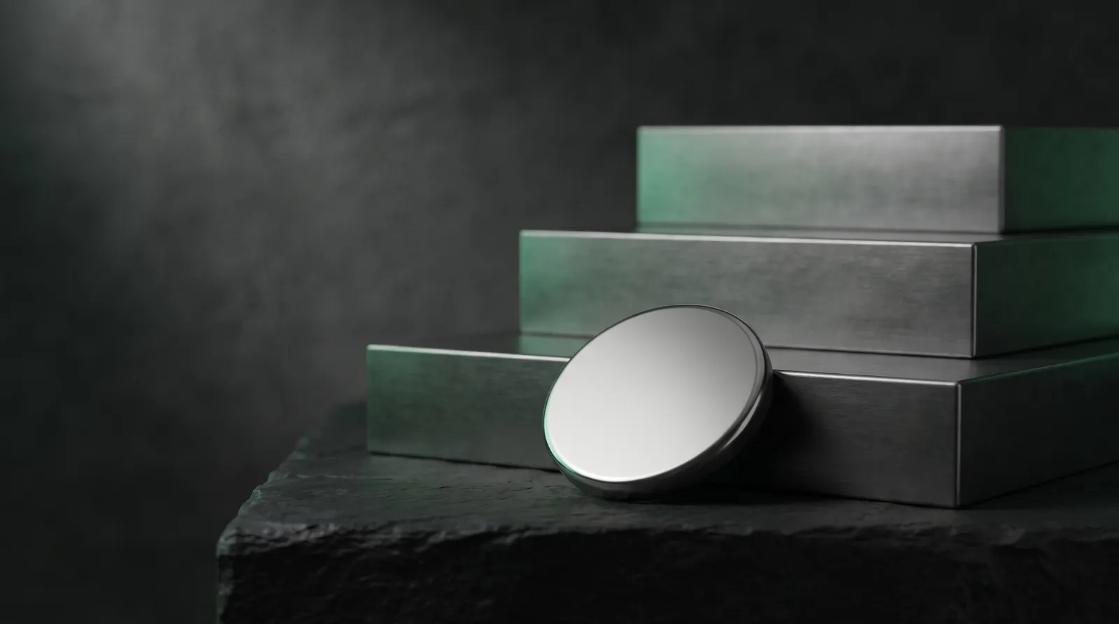 A small polished disc at the foot of three ascending steel steps on dark stone